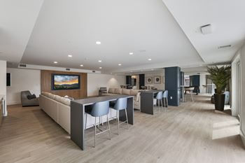 A modern living room with a large television and comfortable seating.